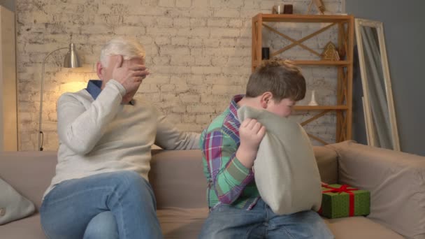 Grandson gives his Grandfather a gift. a fat child gives a gift to An elderly man, Joy, surprise, happiness, emotion, feeling, impulsively, present. Home comfort, family idyll, cosiness concept — Stock Video