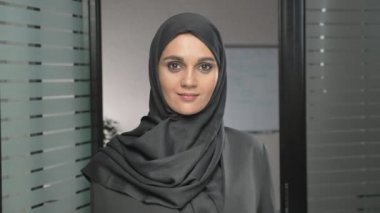 Genç Arap kız hijab sevimli gülümseyen ve kameraya bakıyor. 60 fps