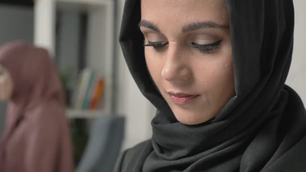 Schönes junges Mädchen im schwarzen Hijab, das Text auf dem Smartphone tippt. 60 fps — Stockvideo