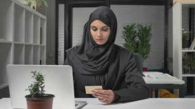 Siyah Tesettür genç güzel kız--dan laptop internette alışveriş yapar. Kredi kartı. 60 fps