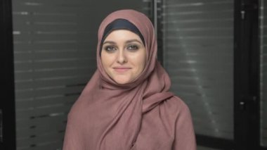 Gülümseyen ve kameraya bakarak pembe hijab genç güzel kız. Portre 60 fps