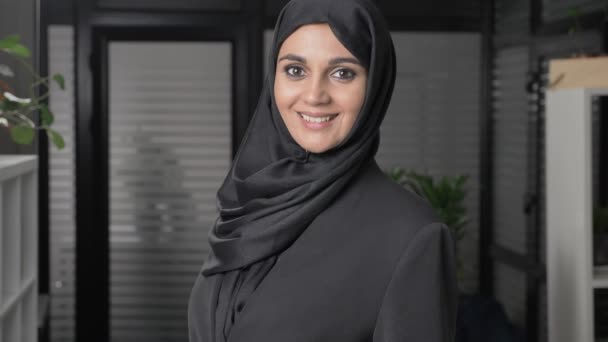 Menina bonita nova em hijab preto sorrindo e olhando para a câmera. Retrato, 60 fps — Vídeo de Stock