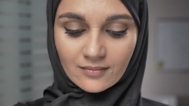 Young beautiful girl in black hijab smiling and looking at camera. Portrait, close up 60 fps — Stock Video