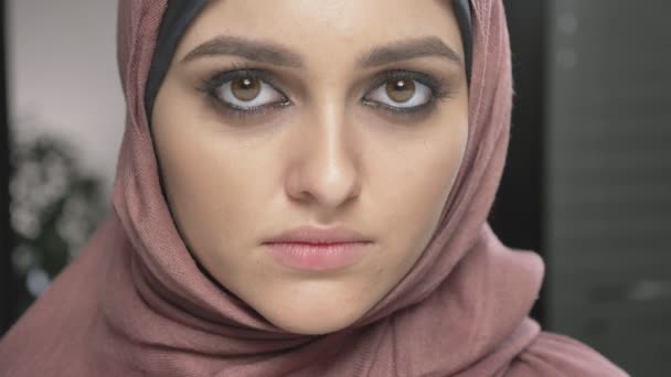 Menina bonita nova em hijab rosa sorrindo e olhando para a câmera. Retrato, close up 60 fps — Vídeo de Stock