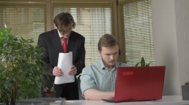 Elbiseli genç adam iki Ofis çalışanları için bir sunum yapar. Düşüncesizce, anlatıyor elleriyle jestleri. Office kavram olarak çalışıyorum. 60 fps
