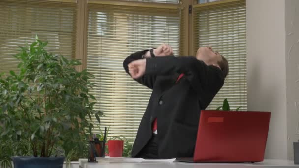 Jonge man in een pak dansen in het kantoor, maakt grappige gezichten, dwazen rond, verheugt zich. Werken in het office concept 60 fps — Stockvideo