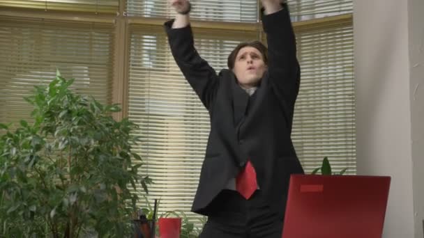 Genç adam bir takım elbise dansları ofiste, komik yüz yapıyor, aptallar, sevinir. Office kavramında işe 60 fps — Stok video