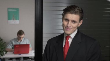 Elbiseli genç başarılı adam utangaçlık, tevazu gösterir. Adam içinde belgili tanımlık geçmiş bir bilgisayarda çalışıyor. 60 fps