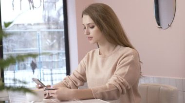 Güzel kadın evde smartphone kullanarak kredi kartıyla alışveriş online. Bir yaşam tarzı. Kameraya bakarak ve gülümseyen güzel kız. Bağlı bankacılık app. kadın telefon ve banka kartı kapalı. 60