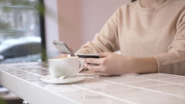 Mooie vrouw online bankieren via smartphone online winkelen met credit card thuis levensstijl. technologie en internet concept - lachende vrouw zitten met smartphone en credit card 60 fps — Stockvideo