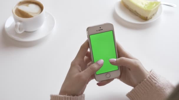 Vacker kvinna händerna med en smartphone i ett café, grön skärm koncept. 60 fps — Stockvideo