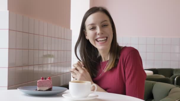 Giovane bella ragazza bruna sorridente e guardando la fotocamera in caffè, ritratto naturale. 60 fps — Video Stock