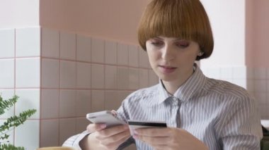 Güzel kadın online banka kredi kartı ile evde yaşam tarzı alışveriş online smartphone kullanarak. teknoloji ve internet kavramı - gülümseyen kadın oturmuş smartphone, kredi kartı 60 fps