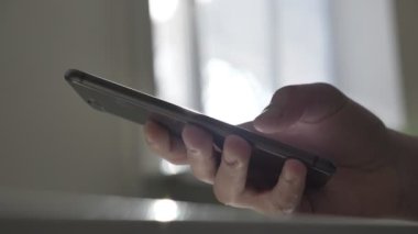 Mens yazarak, ekran, yansıma, ileti kavramı üzerinde güneş ışığı manifatura bir smartphone ver. Güneşli bir pencere içinde belgili tanımlık geçmiş. 60 fps