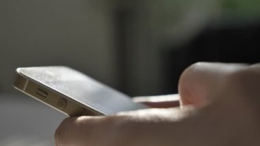 Mens yazarak, ekran, yansıma, ileti kavramı üzerinde güneş ışığı manifatura beyaz smartphone cep telefonu ile eller. Güneşli vurgulamak, ışın, ışın. 60 fps kadar kapatın