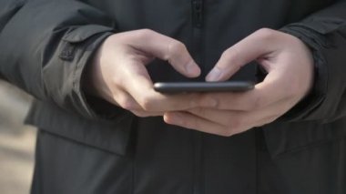 Erkek daha büyük siyah Smartphone'da açık yazarak eller. Manifatura mesaj kavramı. 60 fps