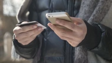 Bir büyük siyah smartphone ve kredi kartı, çevrimiçi bankacılık, alışveriş, online 60 fps mağazası kadın el ele tutuşur