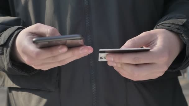 Pánské ruce drží velký černý smartphone a kreditní kartou, on-line bankovnictví, nakupování, online obchod 60 fps — Stock video