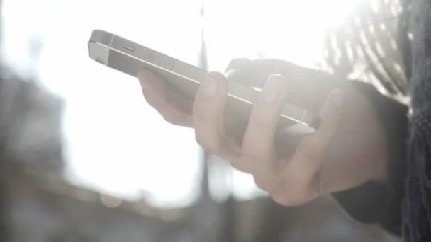 Frauenhände halten ein Smartphone in der Hand, benutzen Smartphone, SMS, tippen Nachricht, scrollen Konzept. Outdoor im Hintergrund 60 fps — Stockvideo