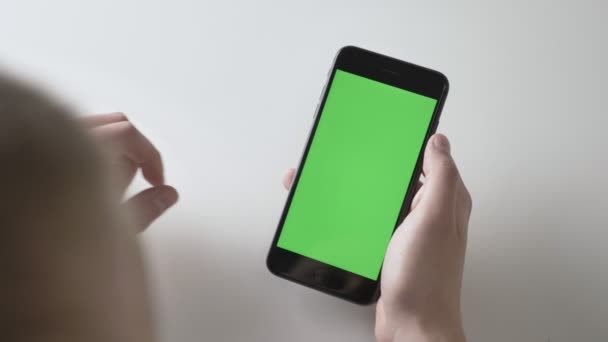 Mani da uomo tengono un grande smartphone nero rendendo pizzico per ingrandire gesto. Schermo verde, cromakey concept 60 fps — Video Stock