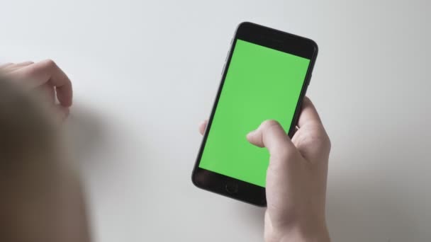 Les mains des hommes tiennent un grand geste de balayage smartphone noir. Écran vert, concept chromatique 60 ips — Video