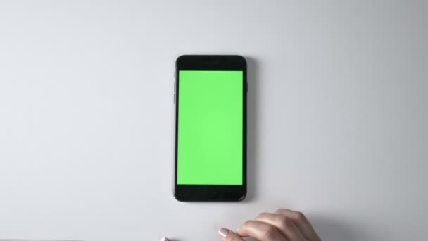 Женщина прокручивает руки на большом черном смартфоне. Зеленый экран, концепция хромакея, 60 кадров в секунду — стоковое видео