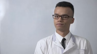 Hayır başını sallayarak, genç kamera, portre kavram başarılı Afrikalı bilim adamı Beyaz önlük ve gözlük görünüyor tarafından jest. 60 fps