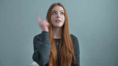 Genç güzel kızıl saçlı kız blogger, kameraya, elini sallayarak kanala abone, bir yorum yazma ve hangi tarihlerde sorar. 60 fps