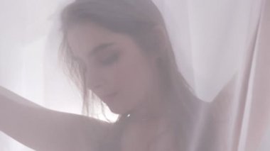 Genç Beyaz sarışın kız dokunuşlar perde, tül ve kamera, portre, iğfal, güneş ışığı arka planda bakar seksi iç çamaşırı kavramı, 60 fps yakından