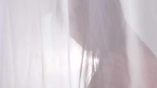 Jeune fille blonde caucasienne en lingerie sexy pour toucher rideau, tulle et regarde la caméra, Portrait, séduction, lumière du soleil en arrière-plan, concept de silhouette, gros plan 60 images par seconde 