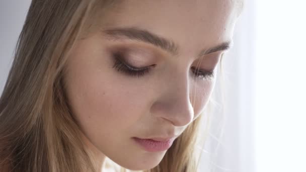 Joven hermosa mujer blanca triste mirando a la cámara, retrato, tentación, luz del día, cerca de la ventana, cortina, 50 fps — Vídeos de Stock