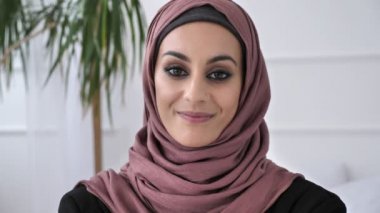 Gülümseyen, gülen ve kameraya bakarak pembe hijab genç güzel Hint kızı. Portre, beyaz arka plan, 60 fps yakından