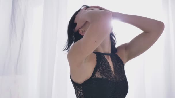 Νέοι σέξι Μελαχρινή καυκάσιος στο μαύρο εσώρουχο, αγγίζει απαλά το κεφάλι, μαλλιά, κλείνει τα μάτια της, κάθεται σε μια χνουδωτή κουβέρτα, κοντά σε ένα παράθυρο, θερινή 50 fps — Αρχείο Βίντεο