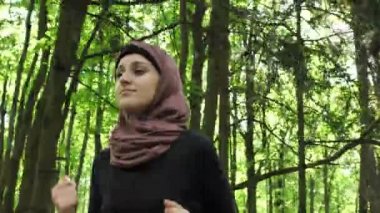 Koşma, yeşil park, orman, koşu hijab genç atletik kız ön görüntülemek 50 fps