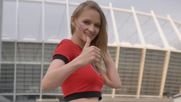 Jong meisje van een blonde voetbalfan van Engeland, lacht, tonen zoals teken, kampioenschap concept 50 fps — Stockvideo