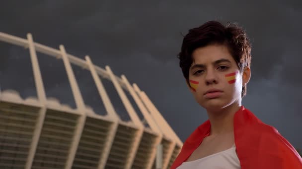Genç esmer kız futbol hayranı seyir kamera, gülüyor, gülüyor, stadyum içinde belgili tanımlık geçmiş İspanya ' nın portresi 50 fps — Stok video