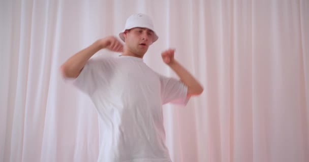 Closeup portrait of young talented caucasian man in bucket hat dancing indoors in apartment — Stock Video