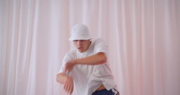 Close-up portret van jonge aantrekkelijke blanke man in emmer hoed dansen binnen in appartement — Stockvideo