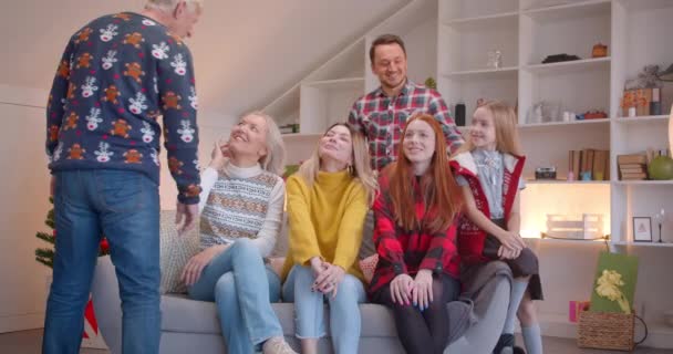 Gran familia se prepara para un retrato en el sofá de Navidad aplaudiendo sonriente feliz — Vídeos de Stock