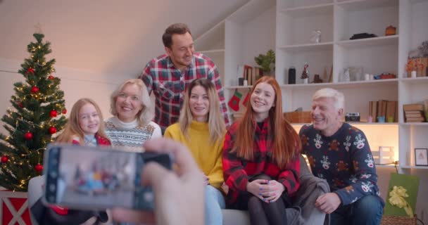 Gran retrato familiar en el teléfono inteligente en el sofá de Navidad feliz sonriendo, riendo — Vídeos de Stock