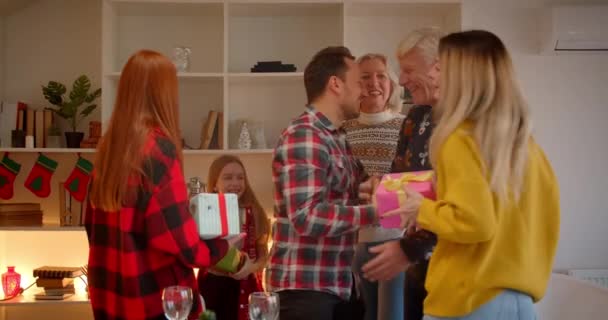 Große Familie tauscht Weihnachtsgeschenke und lachende Enkelin süßes Hausgeschenk — Stockvideo