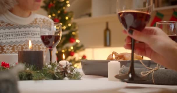 Close-up wijnglazen clink glazen diner familie avond kerstboom comfort voedsel — Stockvideo