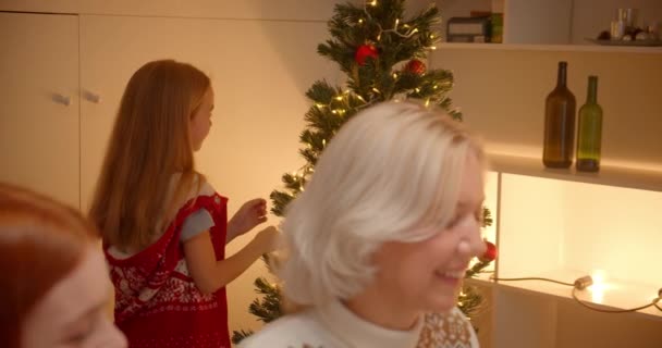 La bambina bionda decora l'albero di Natale. Cena di famiglia. Regali. Vacanze . — Video Stock