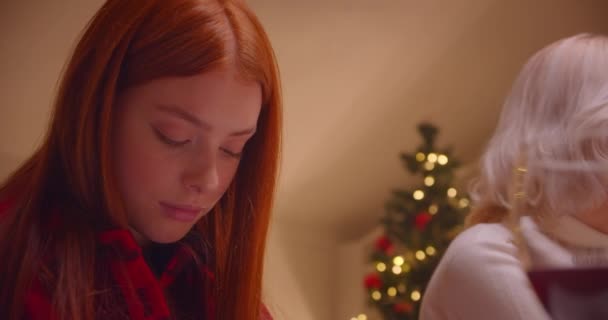 Roodharige meisje tiener oma diner kerstboom avond comfort familie — Stockvideo