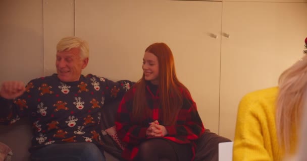 Nagyapa unoka vörös hajú lány lánya meglepetés mosoly ül a kanapén karácsonyi ajándék ad vigaszt családi vacsora este kaukázusi osztálytalálkozó — Stock videók