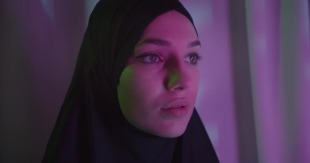 Крупный план портрета кавказской девушки в хиджабе неоновой ночной легкой моде — стоковое видео