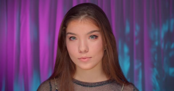 Vackra unga kaukasiska flicka neon ljus bakgrund porträtt — Stockvideo