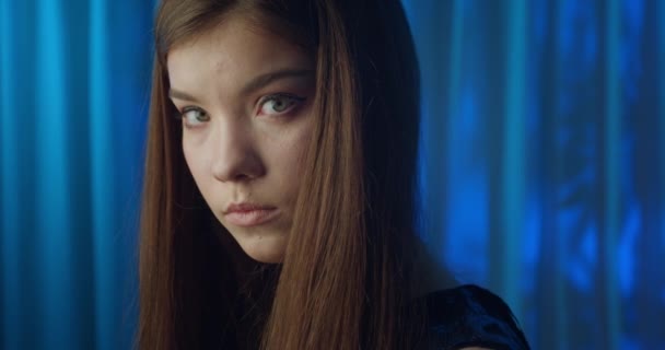 Ögon kaukasiska ledsen flicka porträtt ung färg neon pekar finger lila vind blå bakgrund — Stockvideo
