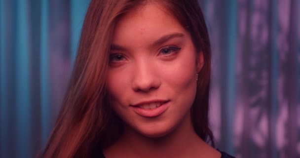 Ögon kaukasiska leende flicka porträtt ung färg neon pekar finger lila vind bakgrund — Stockvideo