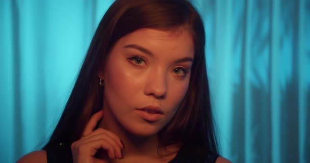 Ritratto giovane caucasico ragazza blu sfondo tenda neon luce sensualità tentazione — Video Stock